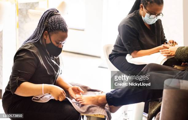 woman having pedicure and manicure at beauty spa during pandemic - pedicure stockfoto's en -beelden