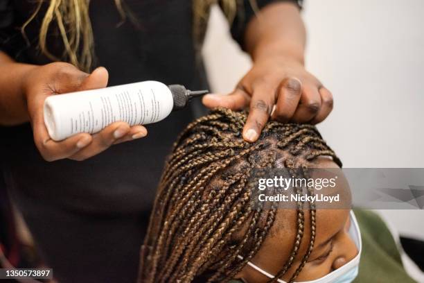 peluquera poniendo aceite en el cabello trenzado de su cliente en el salón - cuero cabelludo fotografías e imágenes de stock