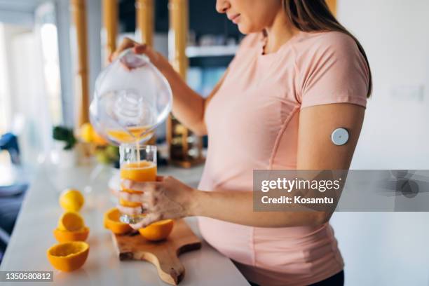 nahaufnahme einer jungen schwangeren frau mit diabetes, die zitronensaft hergestellt hat - diabetes pictures stock-fotos und bilder