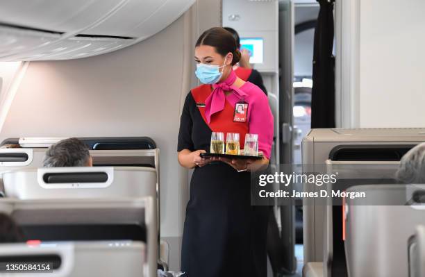 Qantas crew member serves drinks onboard a Boeing 787 Dreamliner aircraft before she takes off at Sydney Airport en route to London via Darwin on...