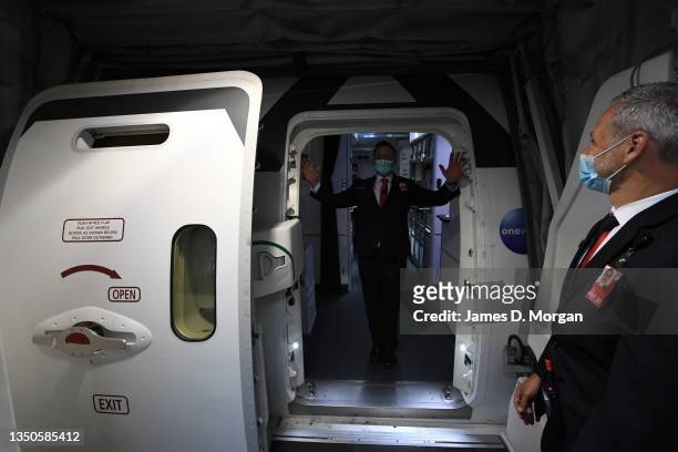 Qantas crew member waves goodbye as another staff member closes the door to QF1, a Boeing 787 Dreamliner aircraft at Sydney Airport en route to...