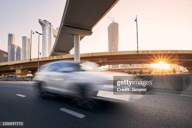 car on highway overpass against dubai cityscape"n - dubai bridge stock pictures, royalty-free photos & images