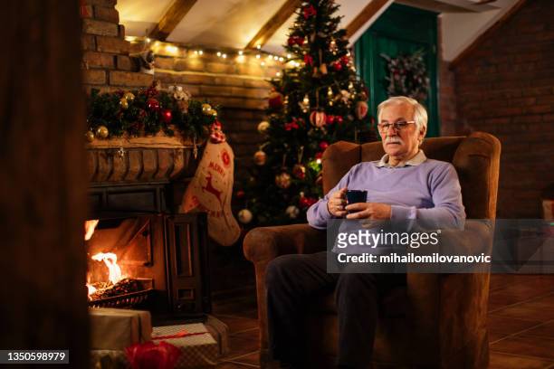 waiting for his family on christmas - sitting by fireplace stock pictures, royalty-free photos & images