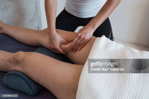 crop masseuse massaging leg of customer - thigh human leg imagens e fotografias de stock