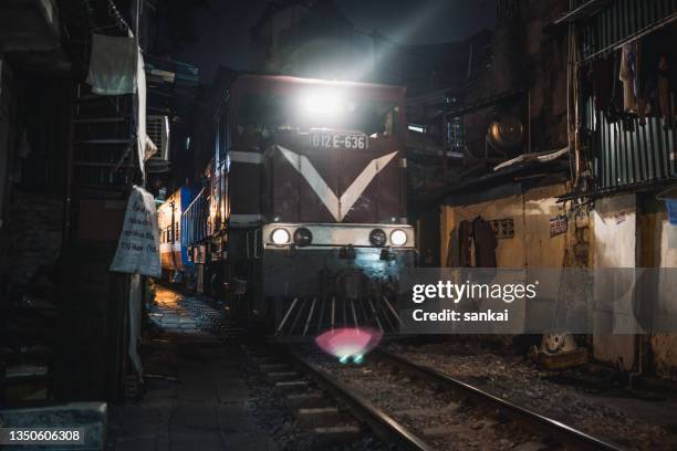 train rides through the narrow street trần phú at hanoi, vietnam - hanoi night stockfoto's en -beelden