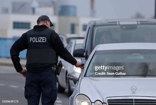 Policeman checks the document of a driver arriving at the German-Polish border on November 01, 2021 in Frankfurt , Germany. Germany's federal police...