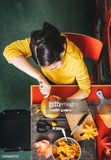 girl carving face from halloween pumpkin - hand stencil stock pictures, royalty-free photos & images