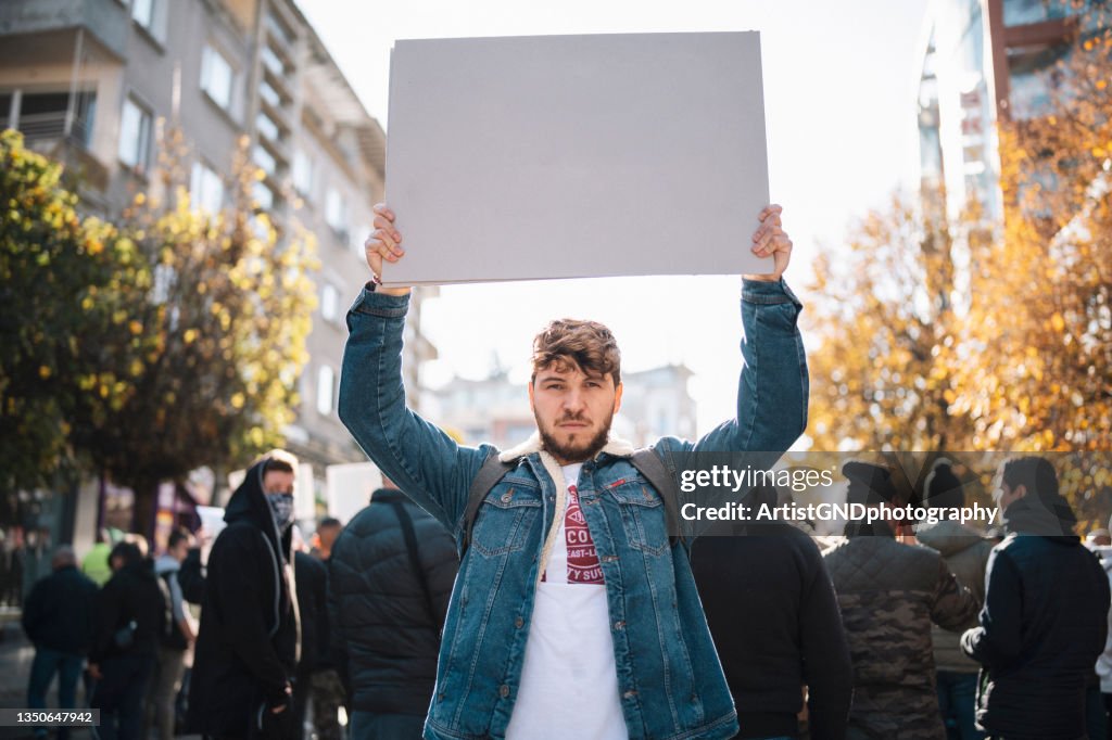 Mann auf Protest mit leerem Plakat.