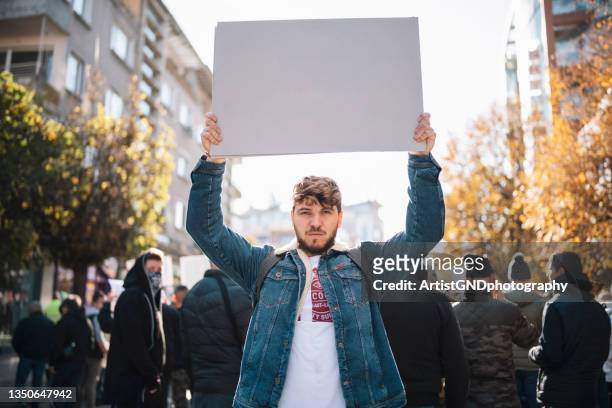 man on protest holding empty poster. - placard imagens e fotografias de stock