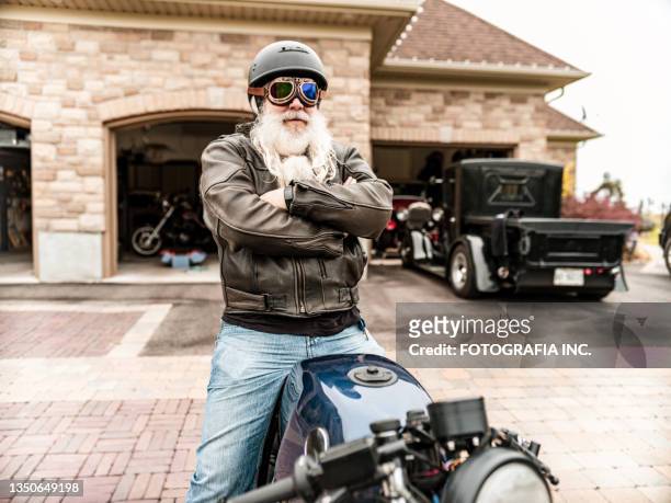 älterer mann bereitet sich darauf vor, sein motorrad zu fahren - biker stock-fotos und bilder