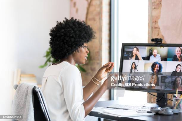 businesswoman gestures during virtual meeting with co-workers - young businessman using a virtual screen stockfoto's en -beelden