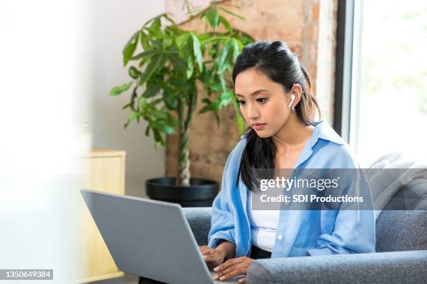 mid adult woman telecommutes using laptop - 25 29 years stock pictures, royalty-free photos & images