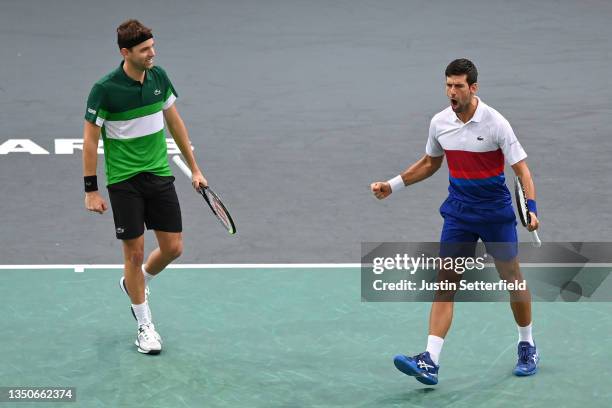 Novak Djokovic of Serbia and Filip Krajinovic of Serbia celebrate after winning the 2nd set against Luke Saville of Australia and Alex De Minaur of...