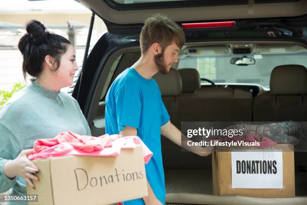 prepping donations for charity. - clear donation box stock pictures, royalty-free photos & images