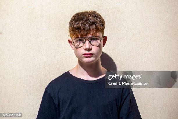 portrait of red-haired teen boy with freckles and eyeglasses - headshot of a teen boy stockfoto's en -beelden