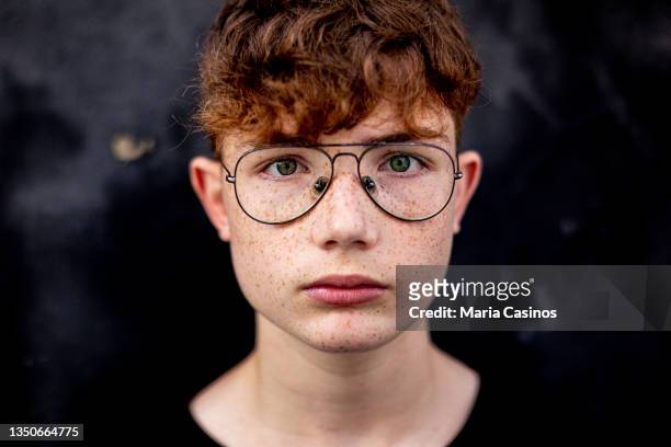 portrait of red-haired teen boy with freckles and eyeglasses - young boy bildbanksfoton och bilder