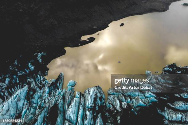 aerial view of the solheimajokull blue glacier with brown lagoon in iceland. - nature reserve stock pictures, royalty-free photos & images