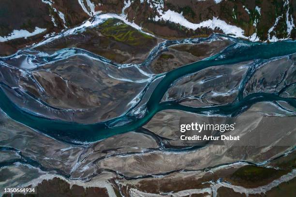 drone view of the highlands mountains of iceland with glacial river. - snow world stock pictures, royalty-free photos & images