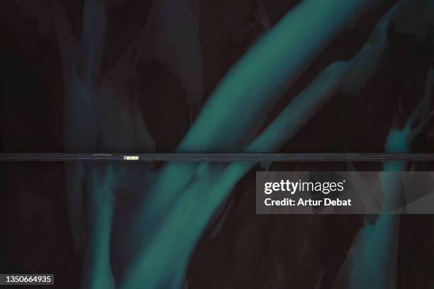 drone view of a car crossing a bridge in iceland with blue steams of glacier water. - murky water stockfoto's en -beelden