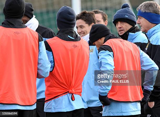 Manchester City's Italian manager Roberto Mancini talks to his players during a training session in Manchester on December 6, 2011 on the eve of...