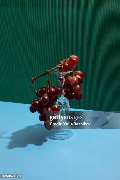 grapes on wine glasses on the blue-green background - pyramide geometrische form stock-fotos und bilder