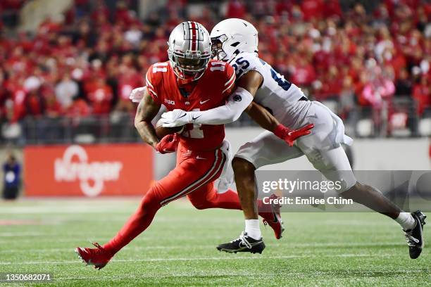 Jaxon Smith-Njigba of the Ohio State Buckeyes carries the ball against Daequan Hardy of the Penn State Nittany Lions during the second half of their...