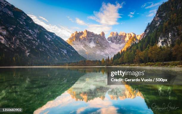 scenic view of lake by mountains against sky,canazei,trento,italy - canazei stock-fotos und bilder