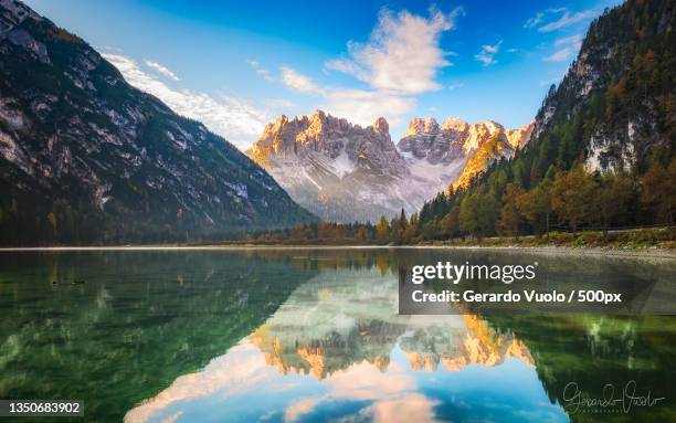 scenic view of lake by mountains against sky,canazei,trento,italy - canazei foto e immagini stock