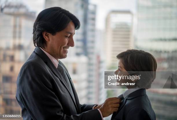 portrait of a happy business man teaching his son how to wear a suit - showing appreciation stock pictures, royalty-free photos & images