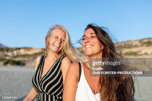 two young and happy woman enjoying a walk on triopetra beach - crete woman stock pictures, royalty-free photos & images