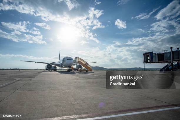 avion à réaction sur le terrain de l’aéroport avec échelle amarrée - aerodrome photos et images de collection