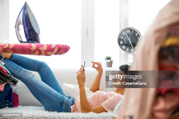 housewife taking a break from ironing - ironing board imagens e fotografias de stock