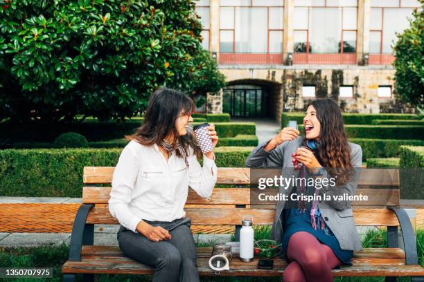 businesswomen during lunch break smiling sitting on a park bench eating their healthy food and zerowaste - reusable cup stock pictures, royalty-free photos & images