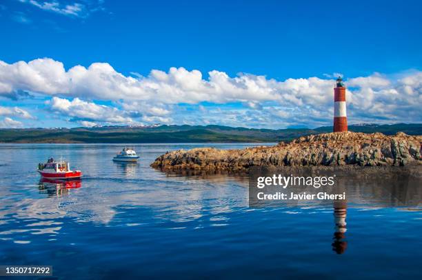 faro les éclaireurs y embarcaciones turísticas. canal beagle, ushuaia, tierra del fuego, patagonia, argentina. - leuchtturm schiff stock-fotos und bilder