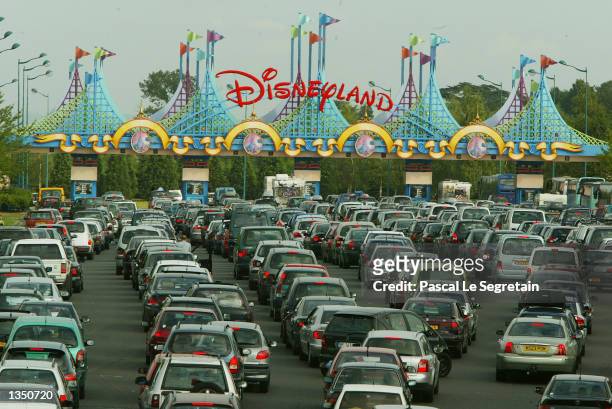 Visitors wait in line at the entrance in their cars at Disneyland Paris August 22, 2002 in Marne la Vallee, France. After a rocky start ten years ago...