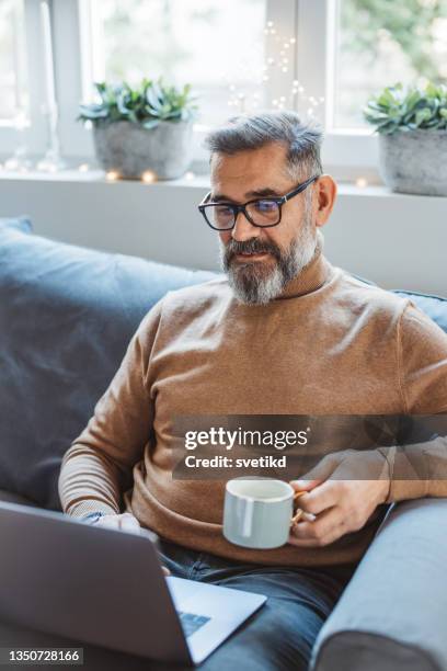 mature man at home for christmas - older man video chat stock pictures, royalty-free photos & images