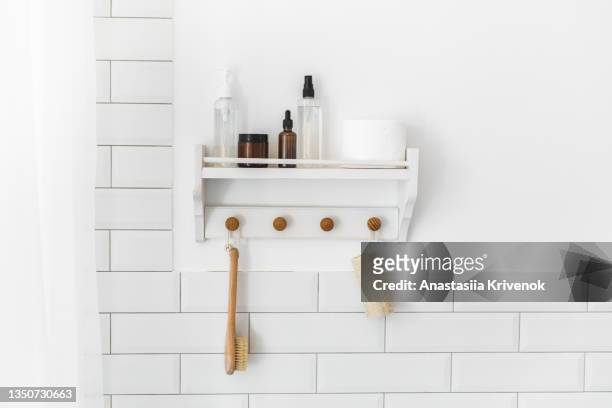 shelf with eco-friendly hygienic supplies and organic toiletries on bath tube, wooden reusable brushes. - sustainable cosmetics stock pictures, royalty-free photos & images