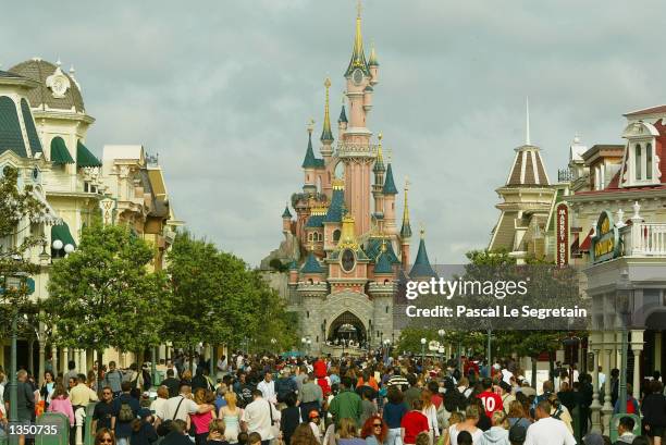 Crowd of tourists walk toward the Sleeping Beauty castle on main street at Disneyland Paris August 22, 2002 in Marne la Vallee, France. After a rocky...