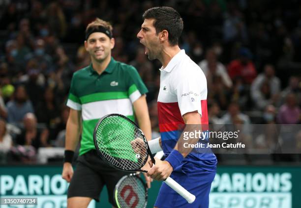 Novak Djokovic of Serbia and teammate Filip Krajinovic of Serbia celebrate winning their first round doubles match during day 1 of the Rolex Paris...
