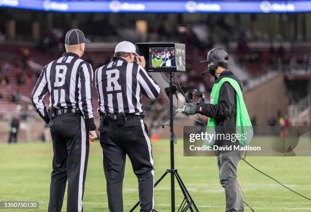 Football officials Back Judge David Ross and Replay Official Jim Fogitance review a play during an NCAA Pac-12 college football game between the...