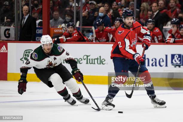 Justin Schultz of the Washington Capitals and Jay Beagle of the Arizona Coyotes in action during the first period of the game at Capital One Arena on...