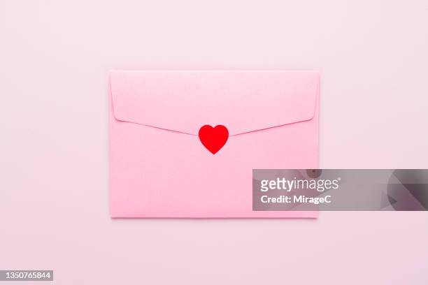 envelope sealed with red heart sticker - love letter stock-fotos und bilder