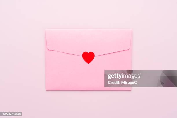 envelope sealed with red heart sticker - carta de amor fotografías e imágenes de stock