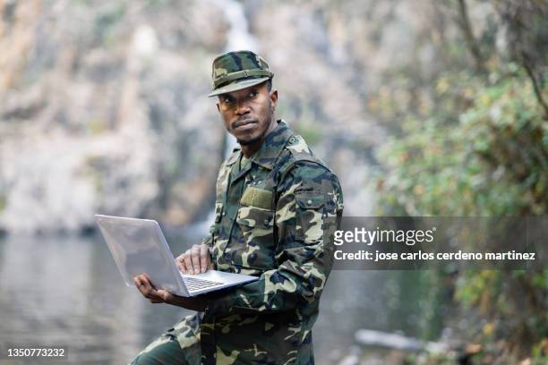 military man of african origin, in the jungle with laptop - military communications stock pictures, royalty-free photos & images