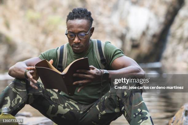 afro american man in military clothes reading a book in the jungle - war veteran bildbanksfoton och bilder