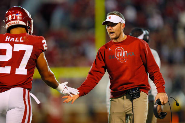 Head coach Lincoln Riley of the Oklahoma Sooners congratulates his team including tight end Jeremiah Hall after a touchdown against the Texas...