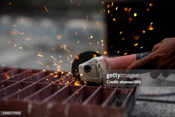 unsafe construction worker  free hand  using electric grinder cut metal at construction site - in flames i the mask stock pictures, royalty-free photos & images