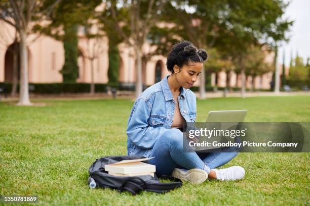 studentessa universitaria che fa i compiti su un laptop sul prato del campus - summer university foto e immagini stock