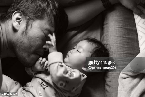 candid facial expression asian baby girl playing with daddy on the bed black and white photography - family photo shoot stock pictures, royalty-free photos & images