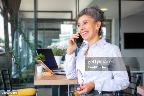 senior women talking on the phone - financieel adviseur stockfoto's en -beelden